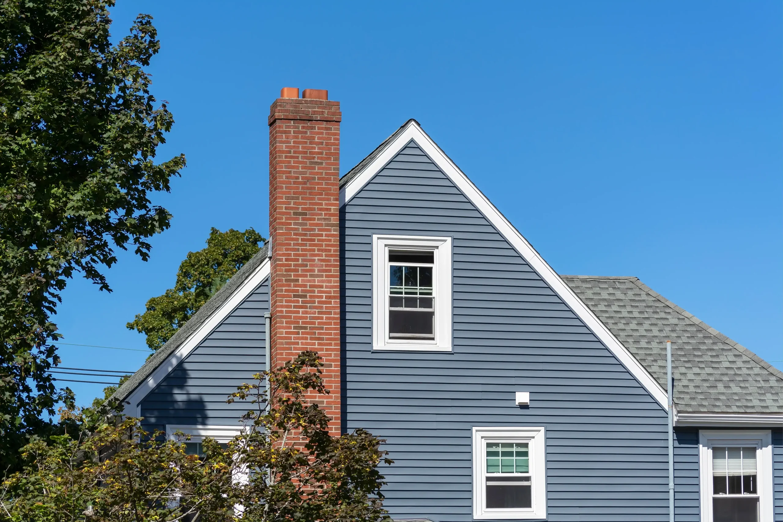 siding-installation-st-paul-mn-blue-home-exterior-with-brick-chimney-and-windows